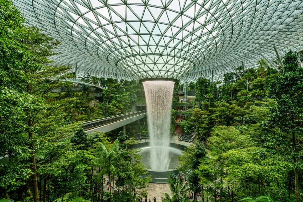 Explore the stunning indoor waterfall and lush green garden at Jewel Changi Airport, Singapore.
